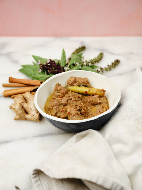 Bowl of food with spices and herbs on a marble surface